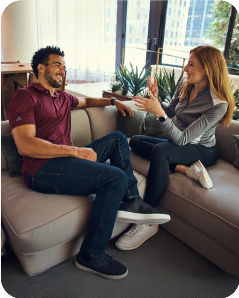 Two people sitting on a couch in a modern office setting